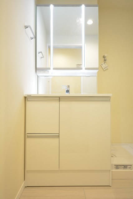 高輪中台マンション　鏡の間にライトがついた洗面化粧台